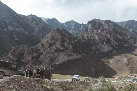 Group traveling by 4x4 SUVs through dramatic mountain landscape, perfect for adventure travel stock photo.