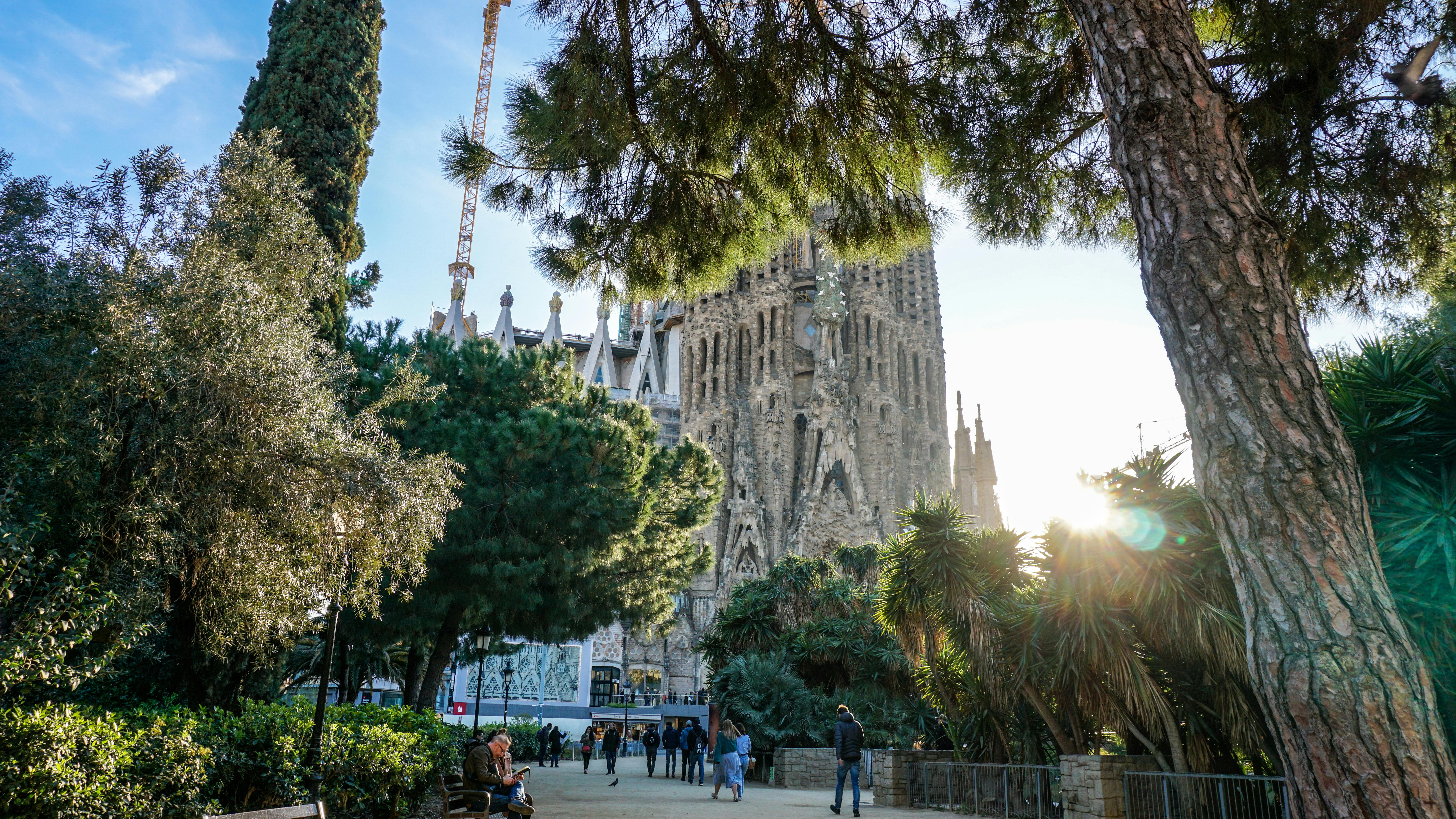 group of people walking in front of sagrada familia cathedral
