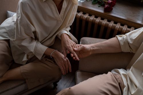 Free A close-up shot of a couple affectionately holding hands indoors, symbolizing love and connection. Stock Photo