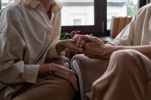 Free A couple gently holding hands, showcasing affection and connection indoors. Stock Photo