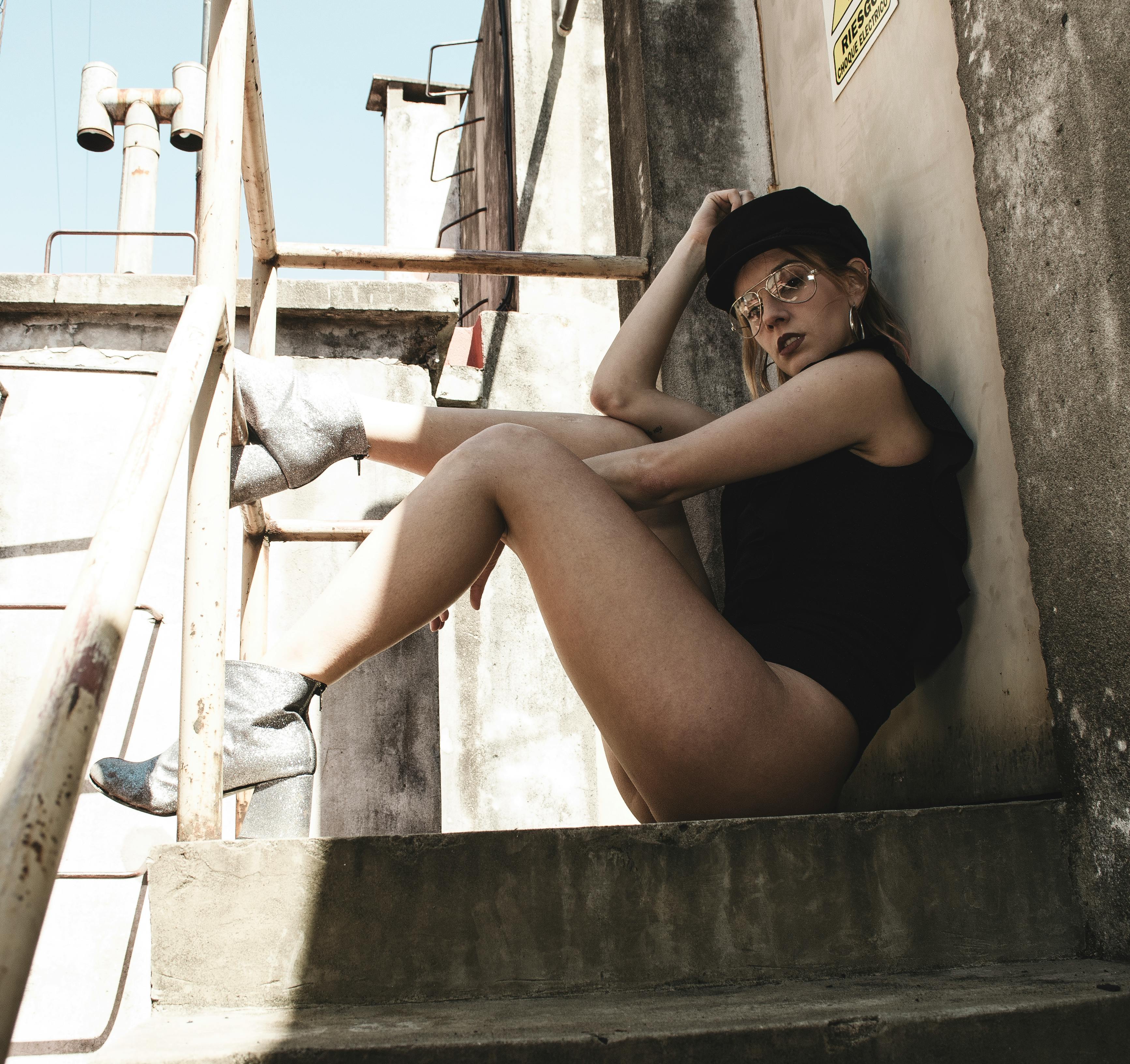 一位时尚女士身着时装，在工业屋顶上摆出姿势，展现现代风尚