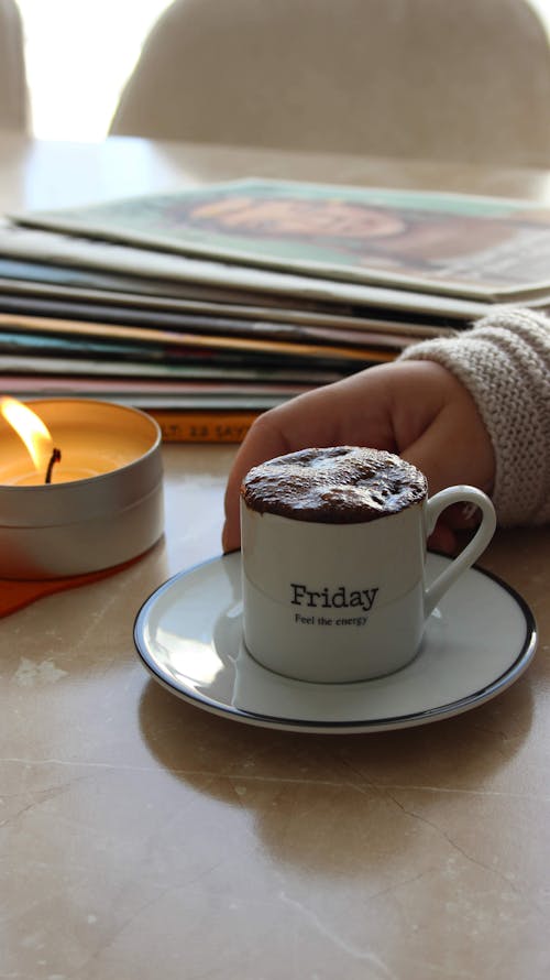 White Ceramic Mug with Coffee Beside a Lighted Tea Candle