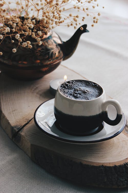 Coffee Cup near Kettle with Flowers