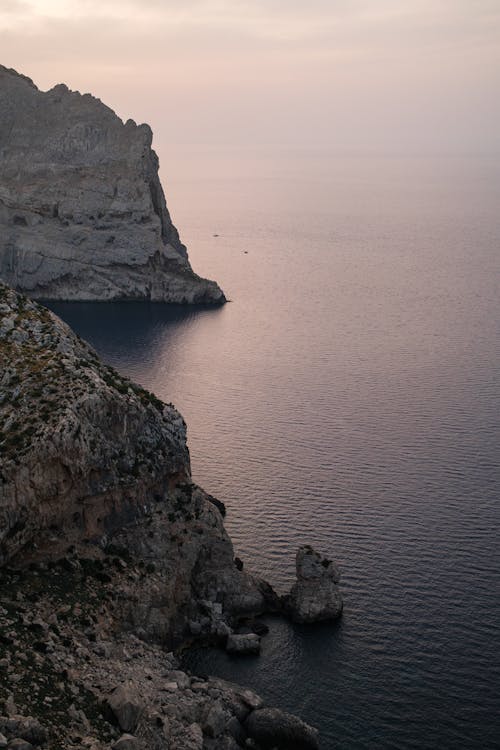 Cliffs Towering over Tranquil Sea at Sunrise