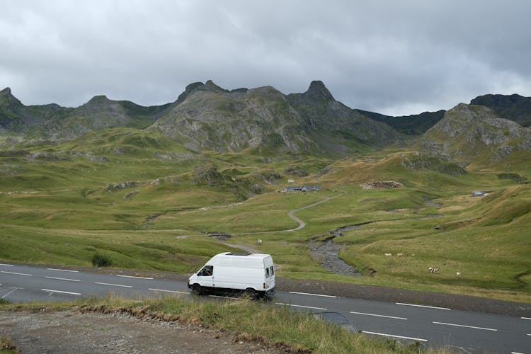 A Side View Of A White Van Driving A Road At Highlands
