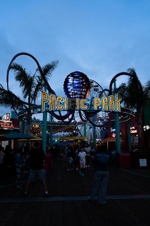 Free People gather at Pacific Park entrance on Santa Monica Pier at dusk, California. Stock Photo