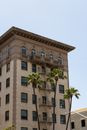 Apartment Building with Fire Escapes and Palm Trees in Foreground