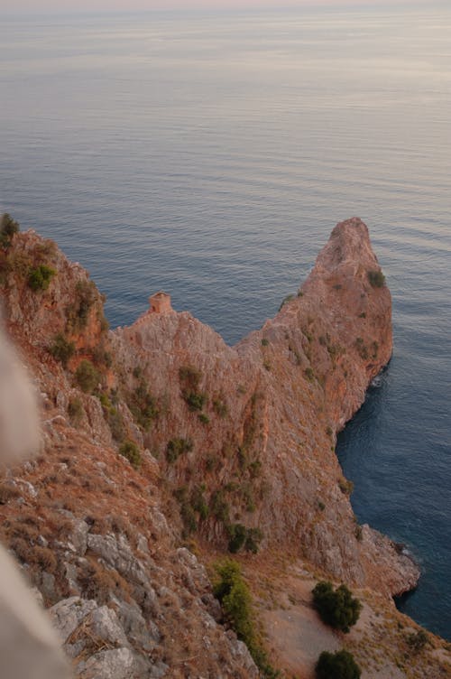 Brown Rocky Cliff Near Body of Water