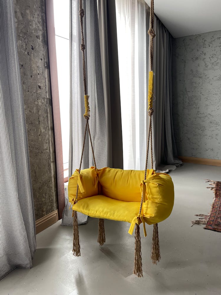 Yellow Indoor Hammock Near The Window With Curtains