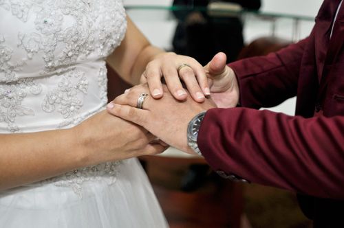 Free Close-up of bride and groom exchanging rings, symbolizing union and commitment during a wedding ceremony. Stock Photo