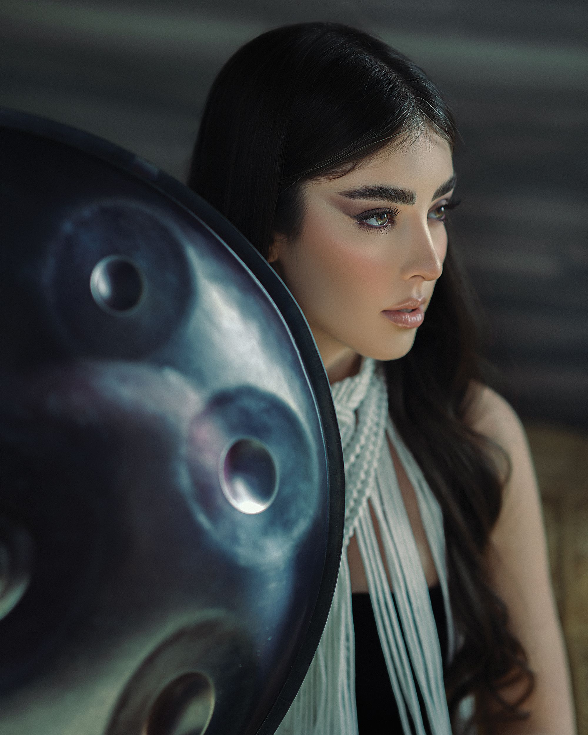 Portrait of a woman with a handpan, showcasing elegance and musical artistry.