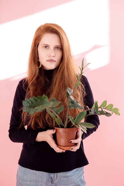 Woman Holding a Plant in a Pot