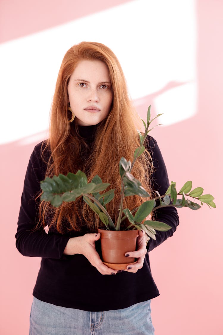 Woman Holding A Plant In A Pot