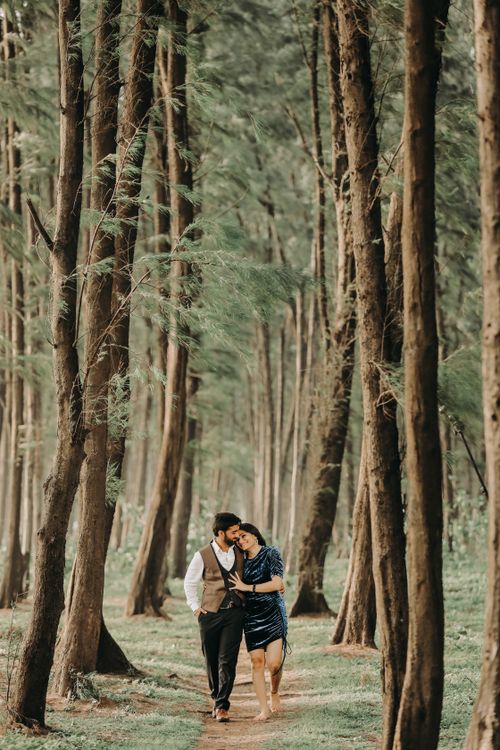 Free A couple walking arm in arm along a serene forest path, expressing love and connection. Stock Photo