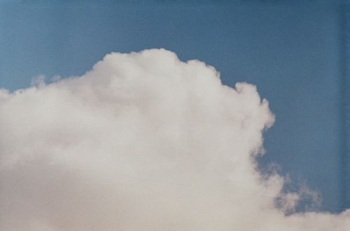 Free A serene cumulus cloud floats in a clear blue sky, evoking calmness. Stock Photo