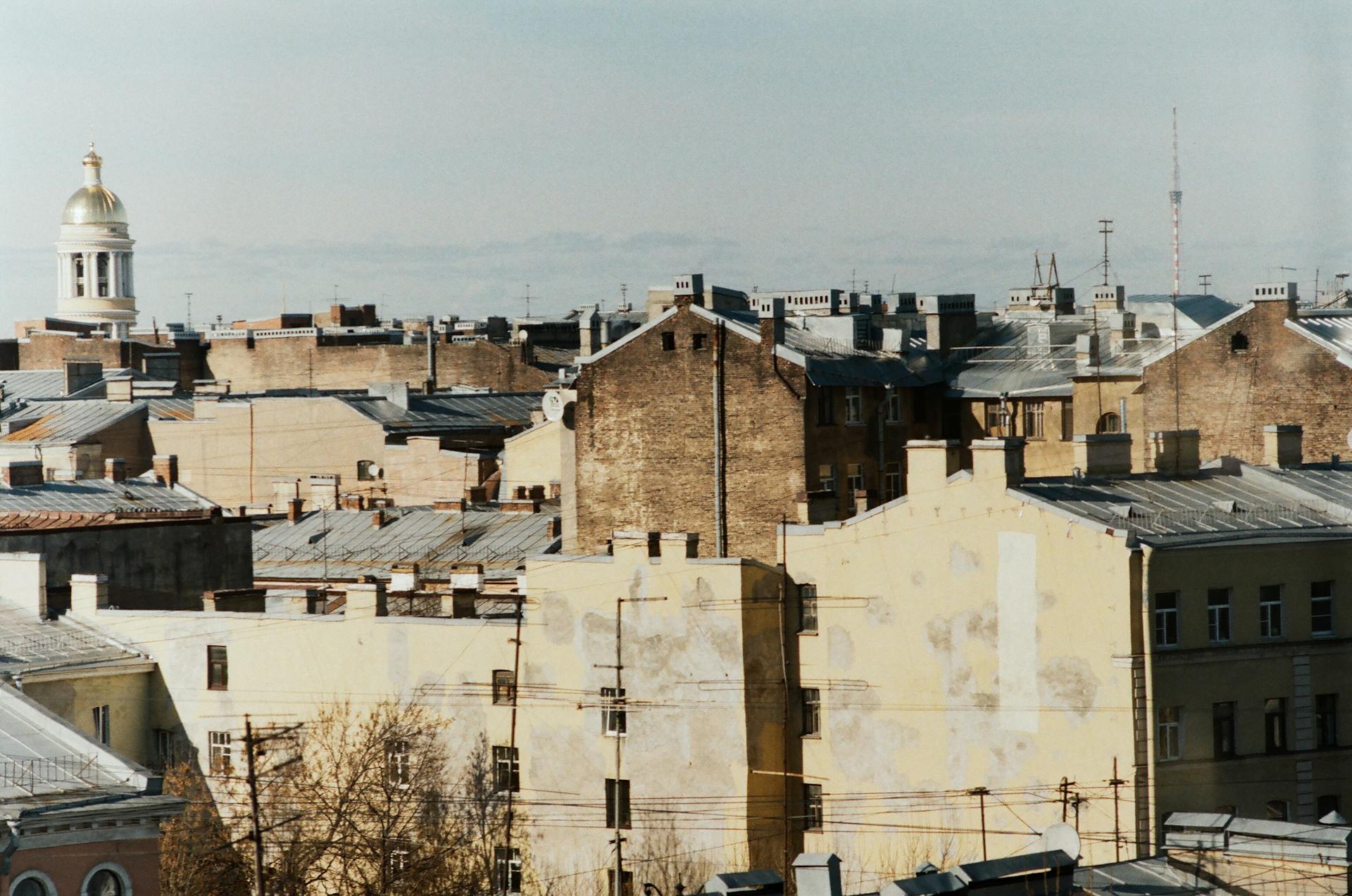 Aerial view of old European cityscape featuring historic rooftops and a golden dome.