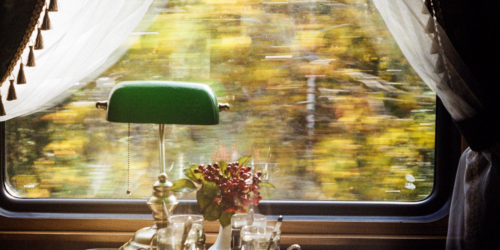 A cozy vintage train interior with scenery outside the window