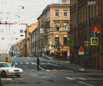 A lively urban street showcasing pedestrians and classic architecture under a clear sky.