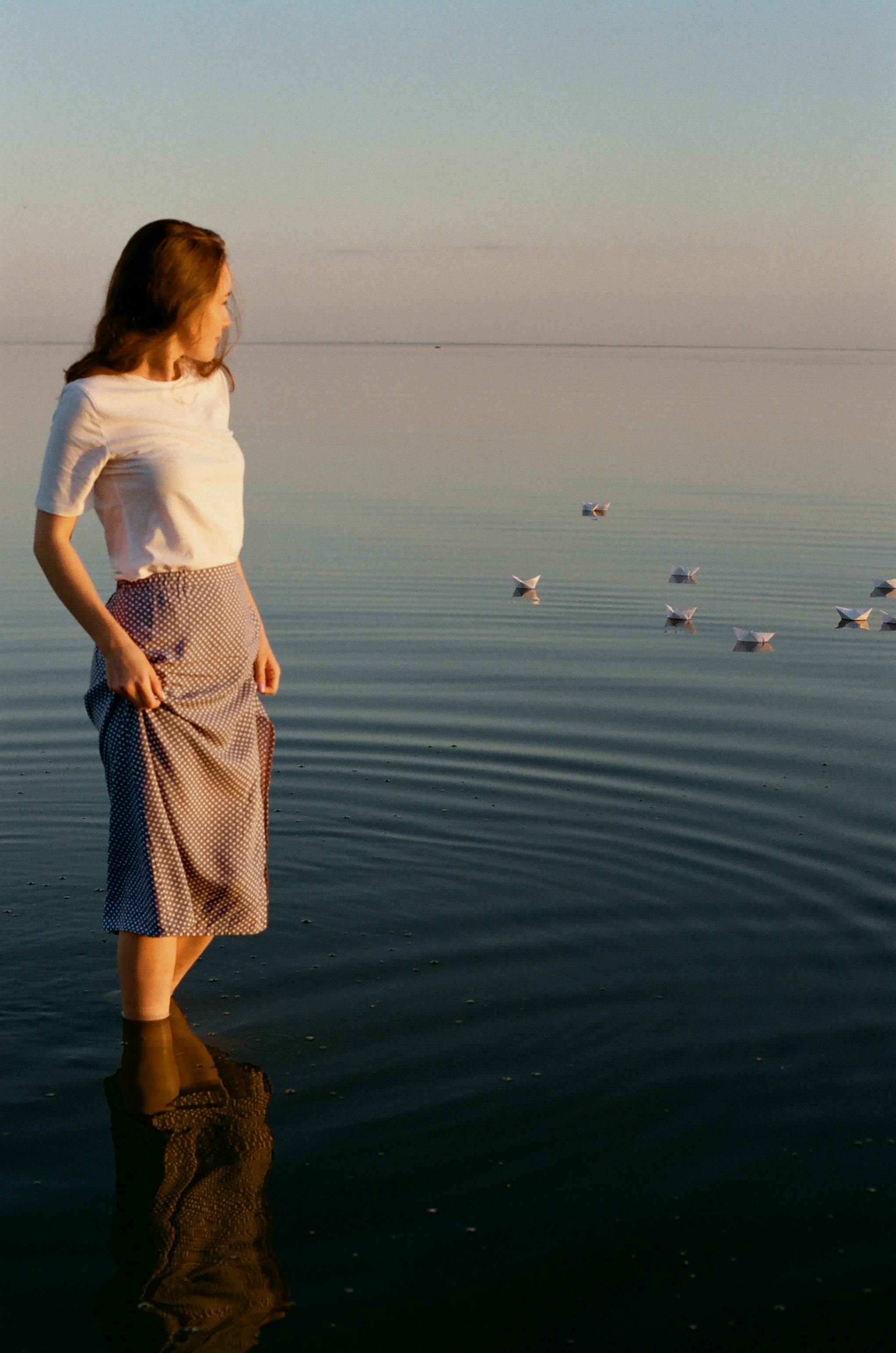 portrait of woman in skirt standing in water