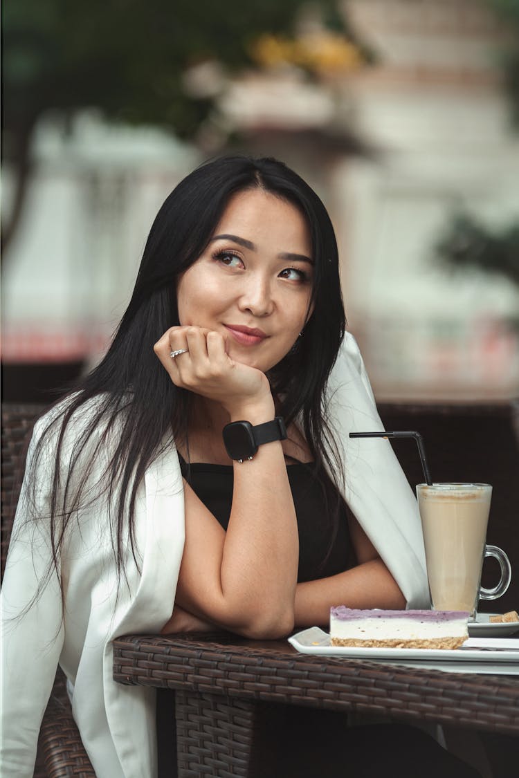 Smiling Woman Having Coffee And Cake At Sidewalk Cafe