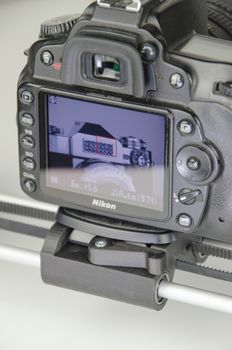 Close-up shot of a camera LCD screen displaying an object in a macro setting with visible sliders.