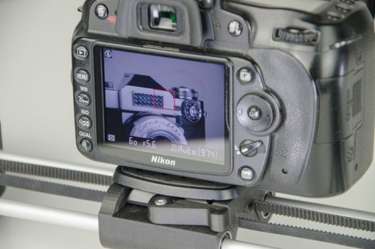 Close-up view of a DSLR camera on a slider with focus on the screen display.