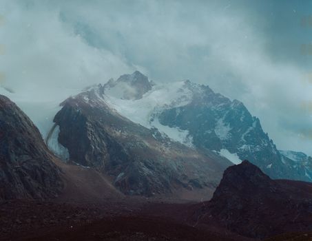 Scenic winter view of snow-covered mountains and cloudy skies in Almaty, Kazakhstan.