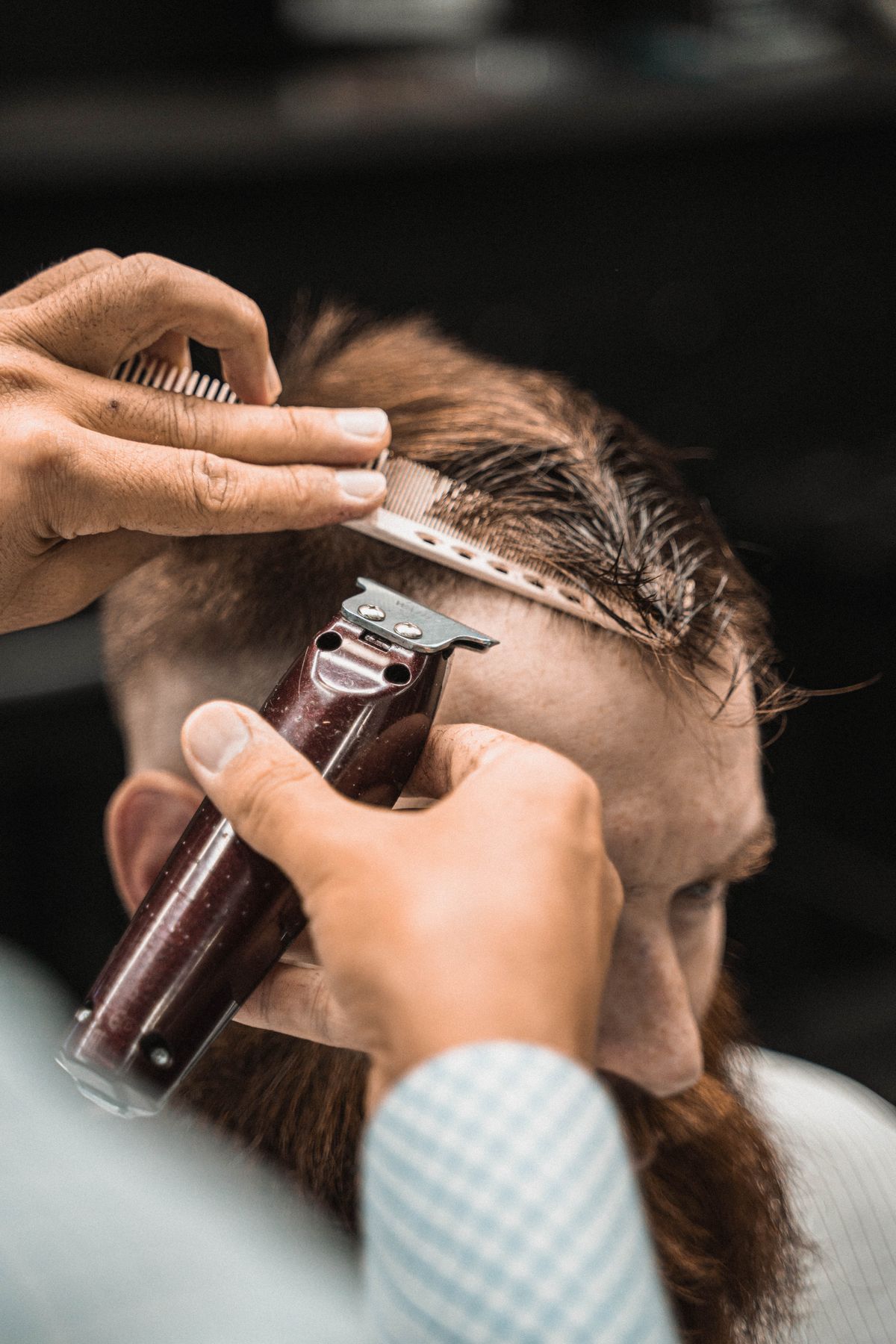 Close-up of a barber cutting a client’s hair with clippers