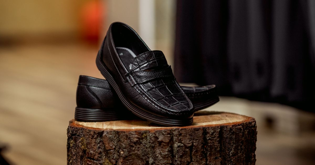 Flat leather loafers on a person stepping onto a subway platform