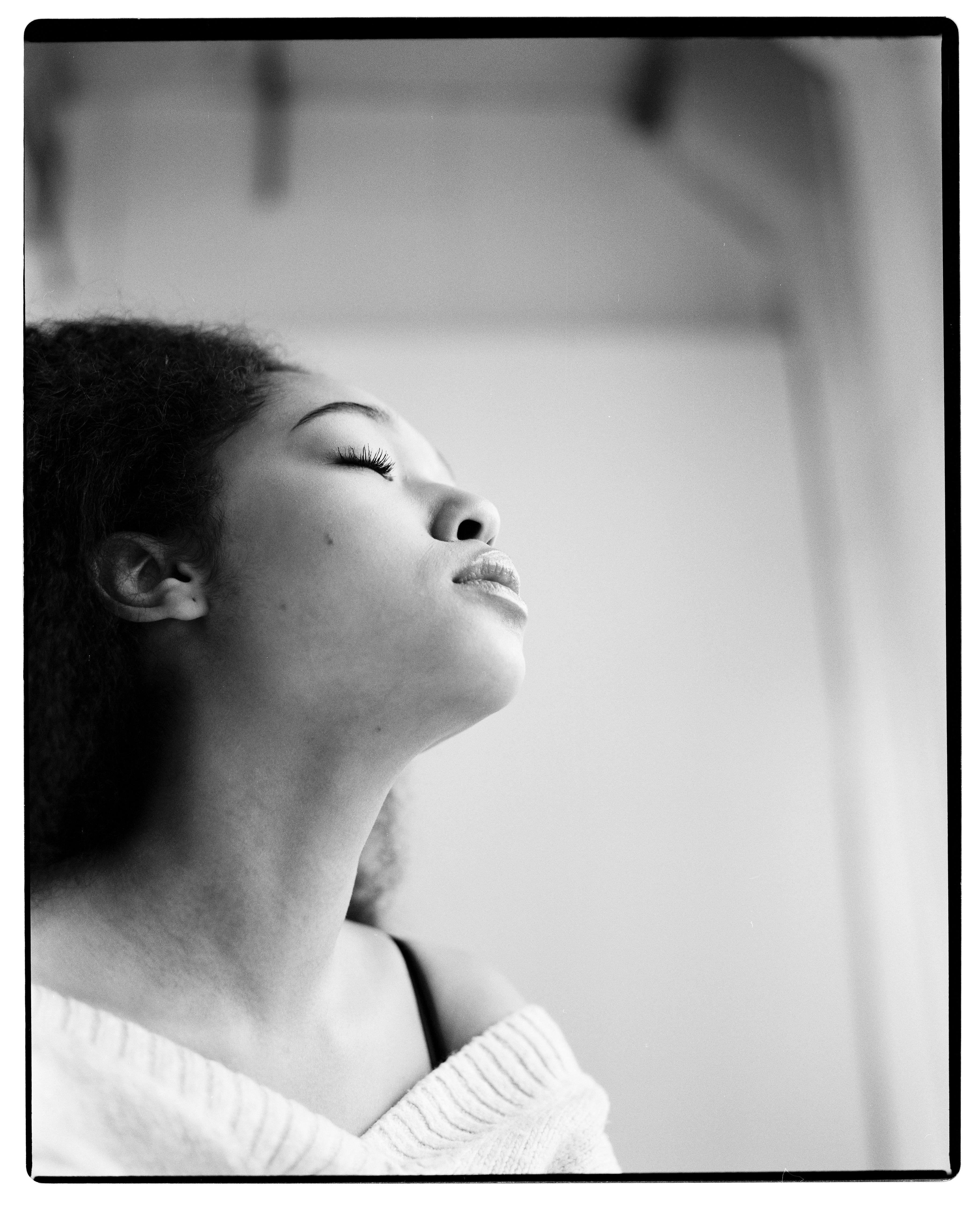 Elegant black and white portrait of a woman with eyes closed, exuding serenity.