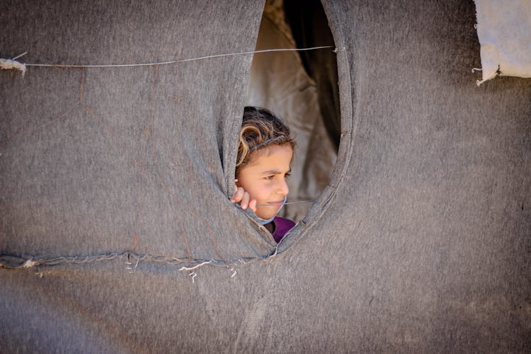 A Child Peeping In A Tent