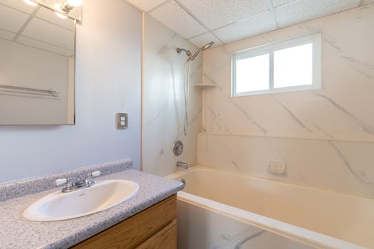 Elegant bathroom featuring a shower-tub combo and stylish vanity, filled with natural light.