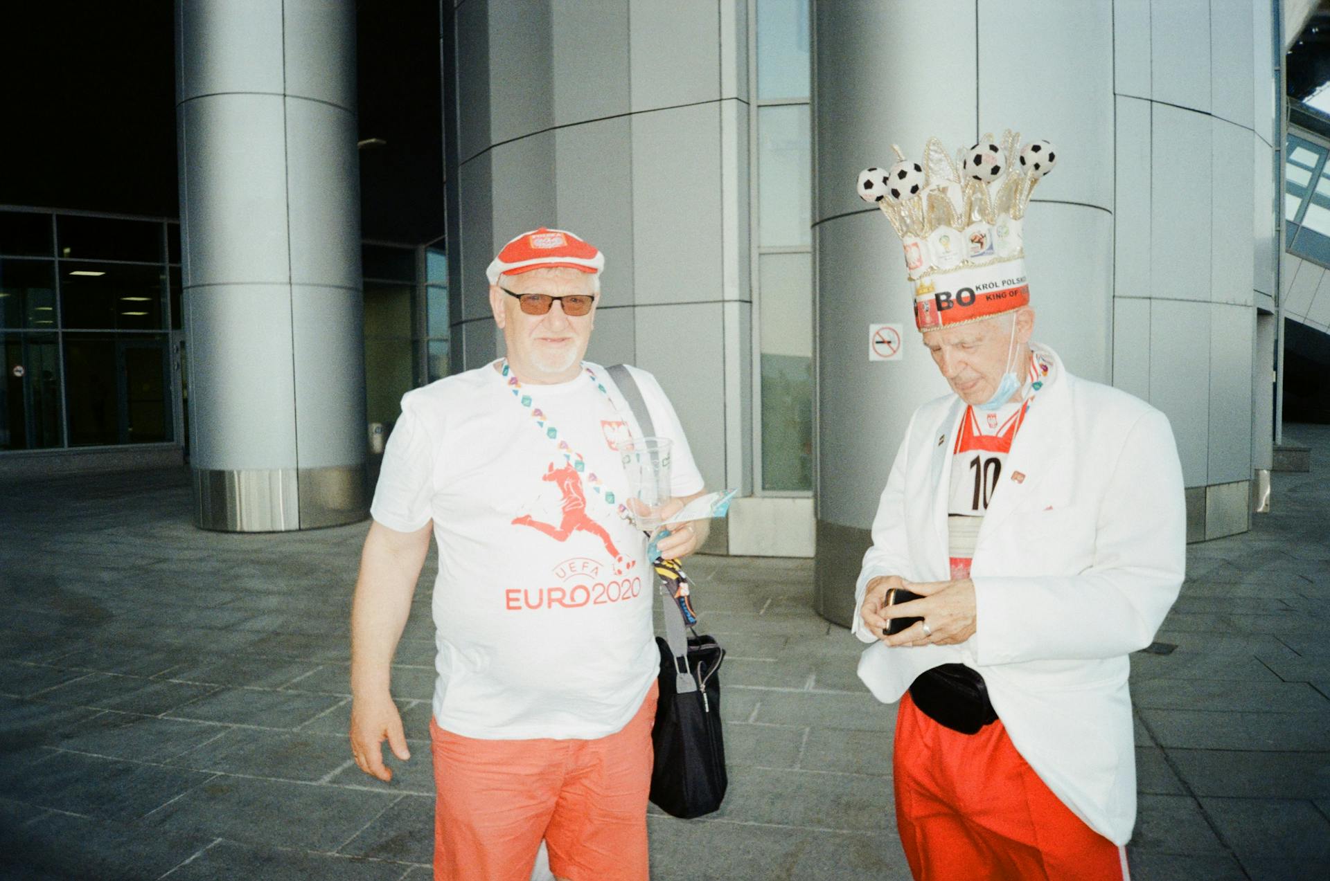 Two passionate Polish football fans proudly display their support at a Euro 2020 venue.