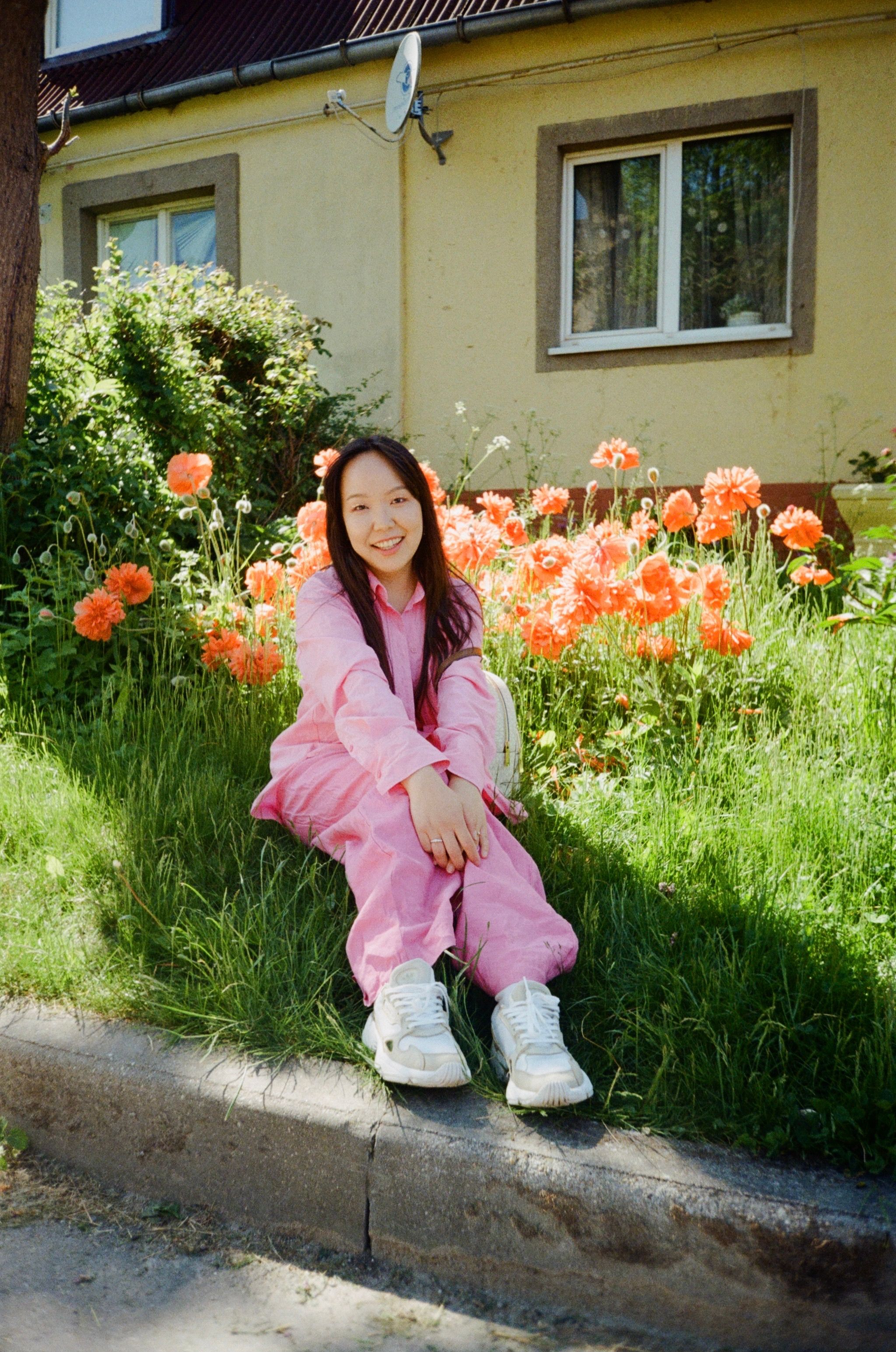 Photo of a Woman in Pink Clothes Sitting Near Red Flowers · Free Stock ...