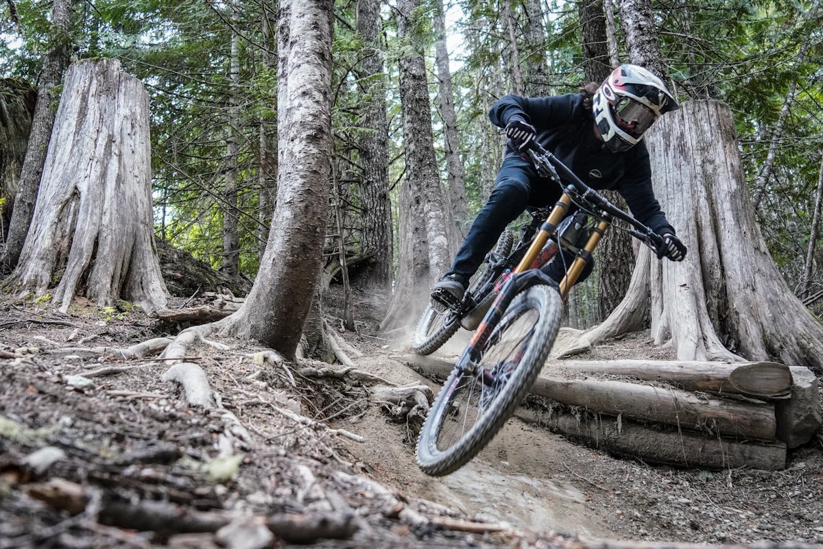 Mountain biker tackling a challenging forest trail at high speed