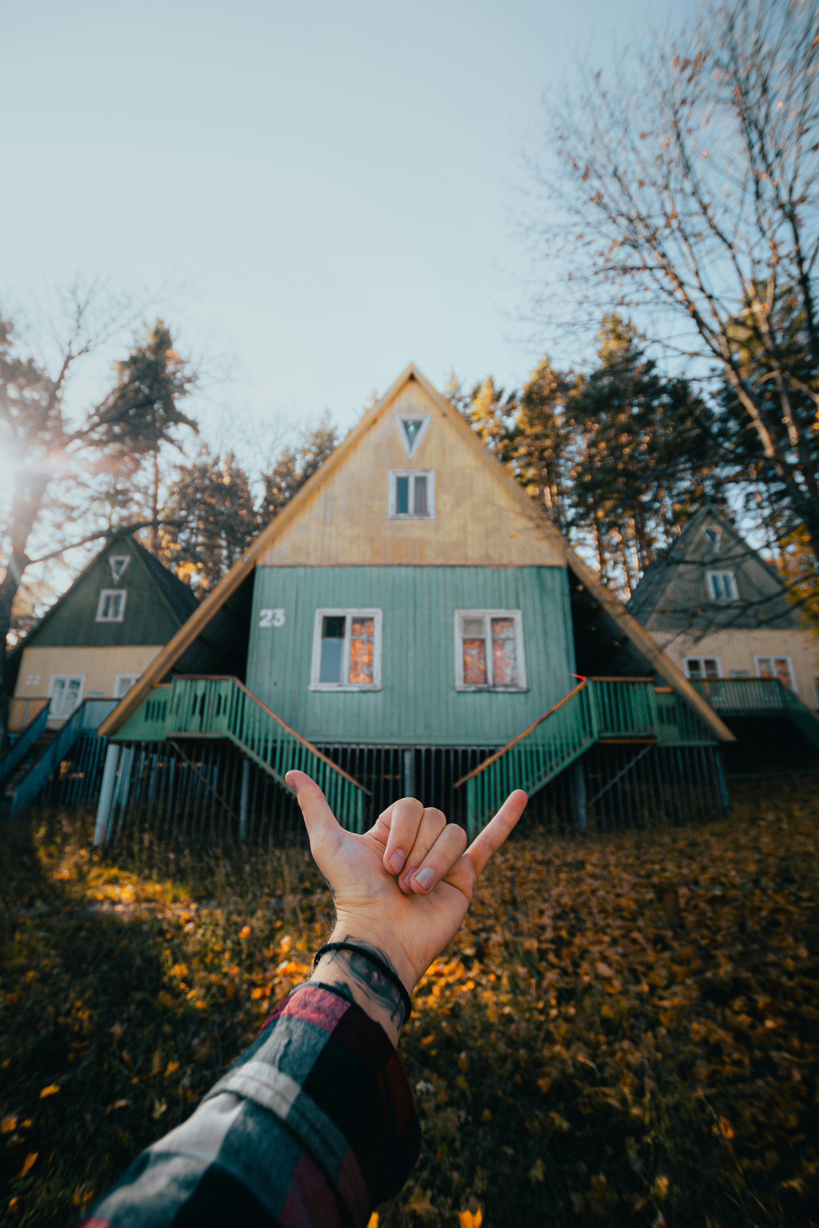 a point of view shot of a hand gesturing with a wooden houses in background