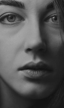 Intimate grayscale portrait of a woman, focusing on facial features.