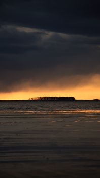 Stunning seascape at sunset with dramatic clouds and golden light over the ocean.