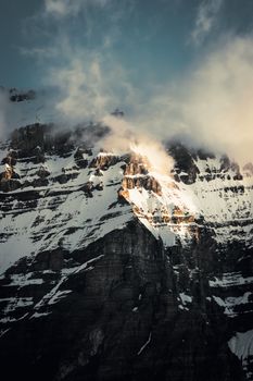 Sunrise illuminates the rugged, snow-covered peaks of Banff's majestic mountains.