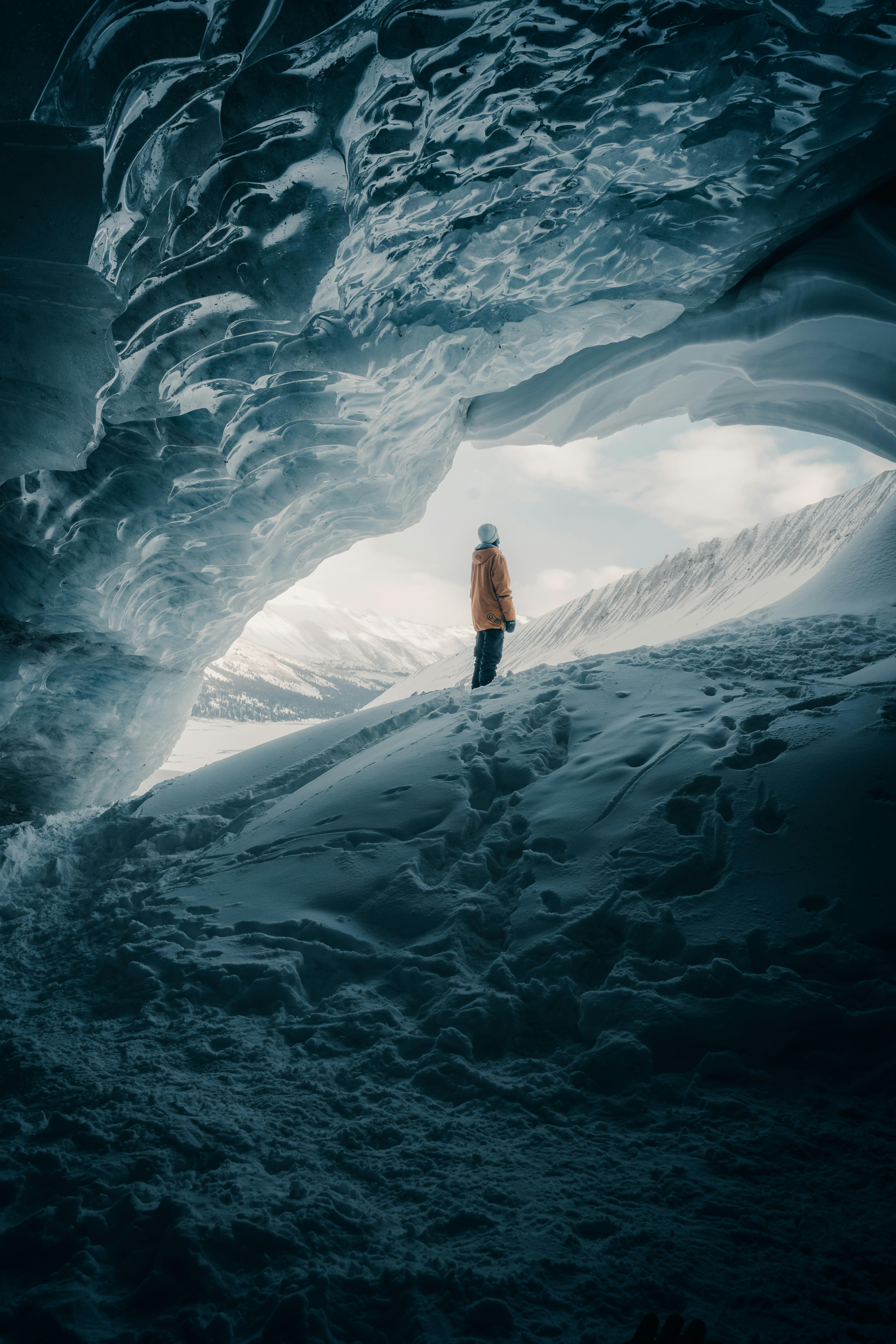 person standing next to glacier