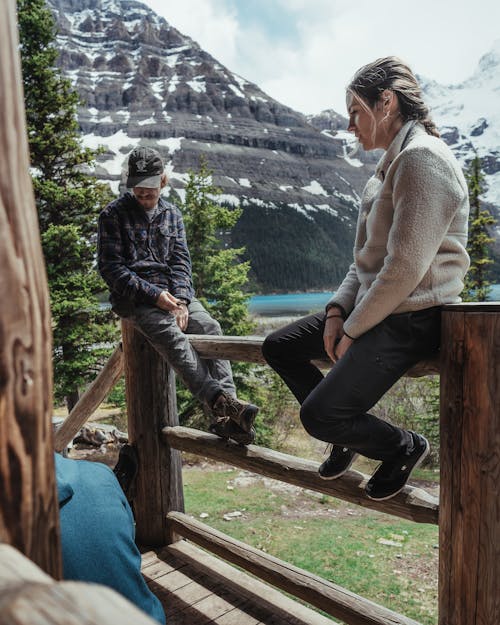 Man and Woman Sitting on the Wooden Fence