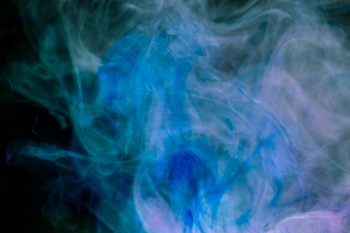 Free Dynamic abstract image of blue and purple smoke swirls on a dark background. Stock Photo