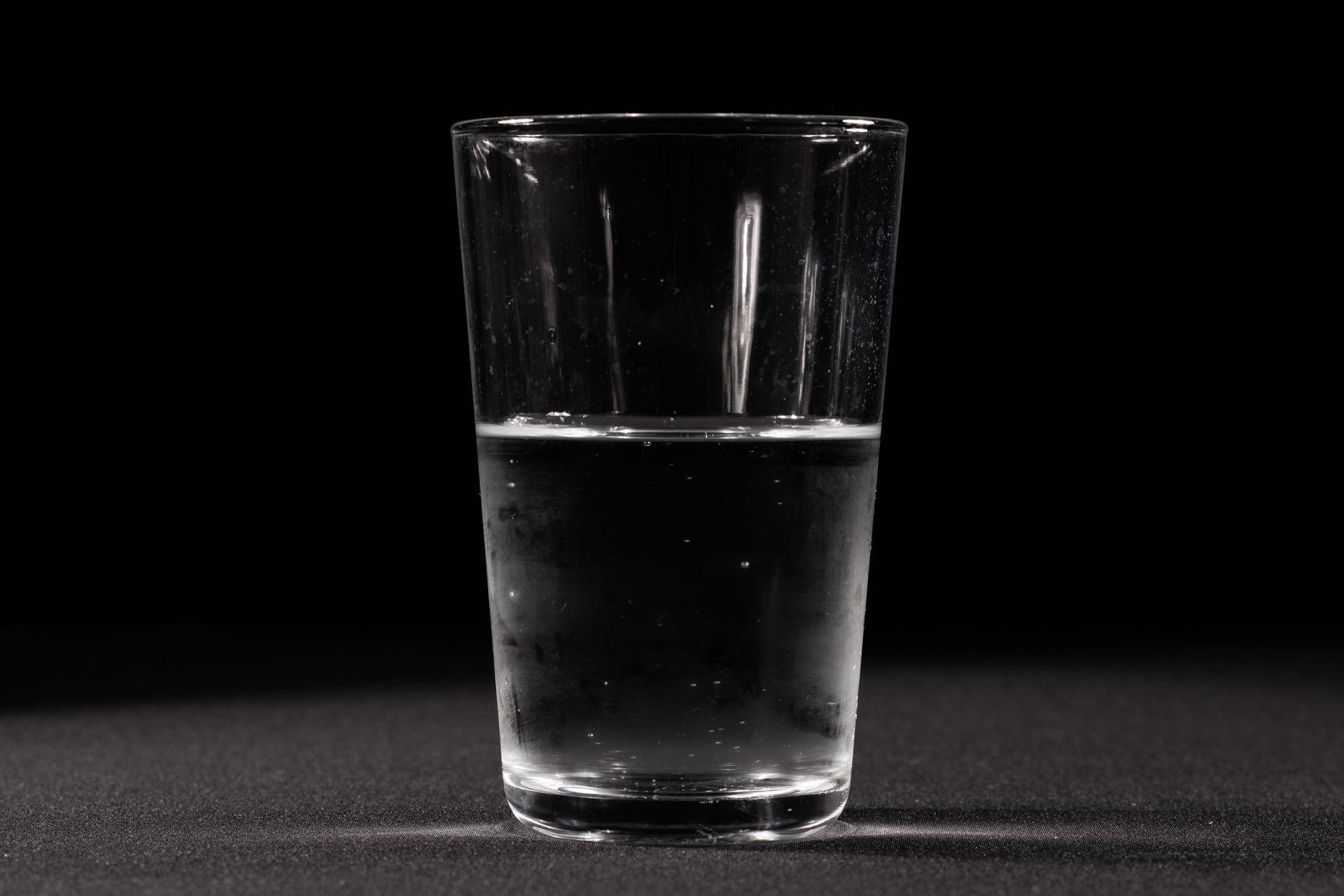 hydrogen peroxide water hack — A clear glass of water set against a dark background, showcasing simplicity and purity.