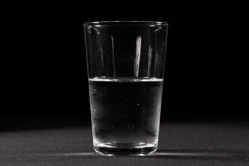 Free A clear glass of water set against a dark background, showcasing simplicity and purity. Stock Photo