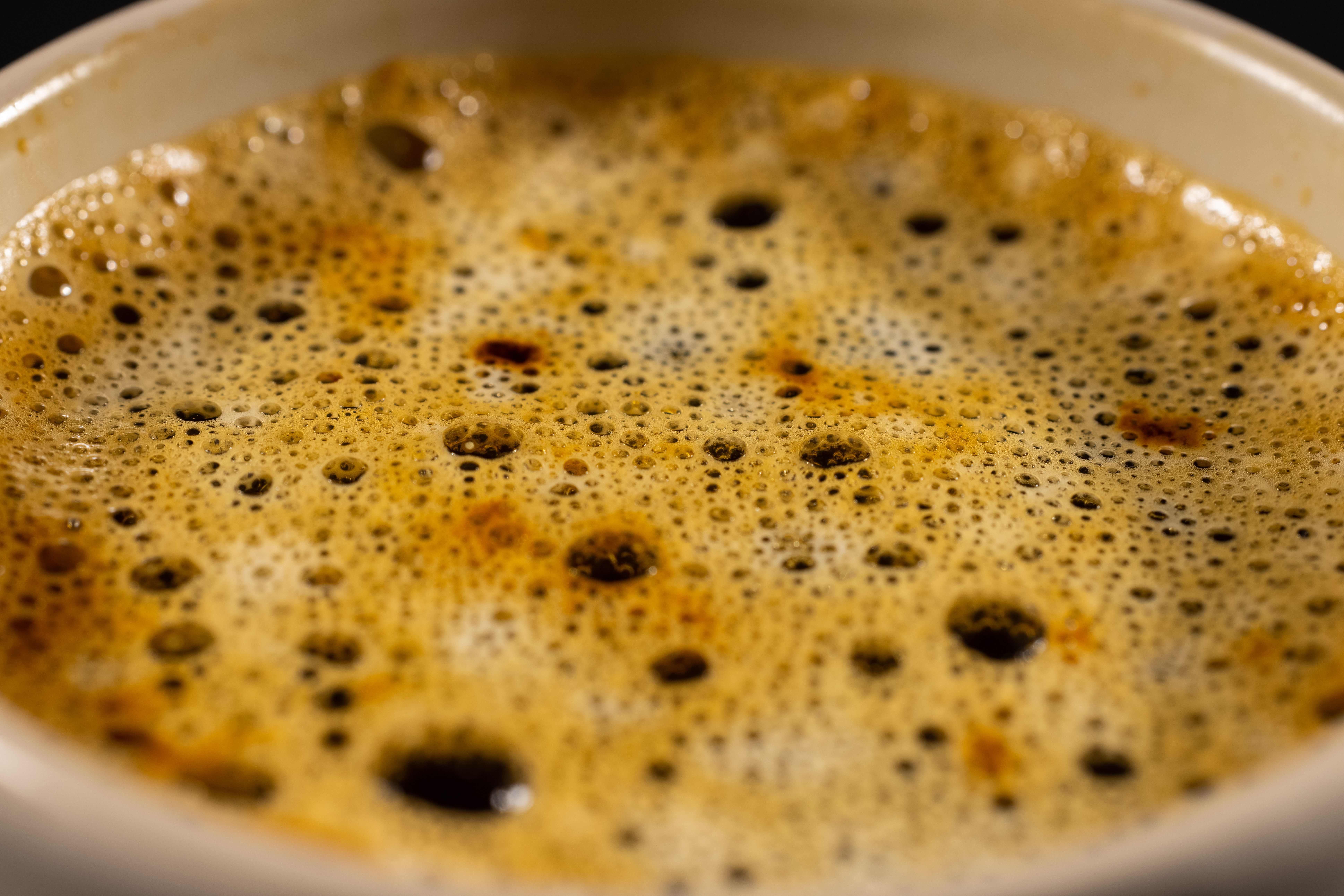 A close-up of an espresso cup on a café table, with a delicate pastry nearby.