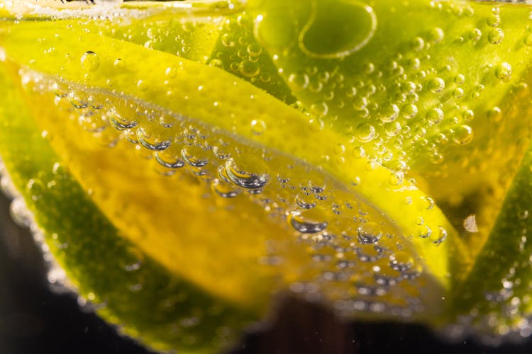 Macro Shot Photography Of Sliced Limes On A Glass Of Soda