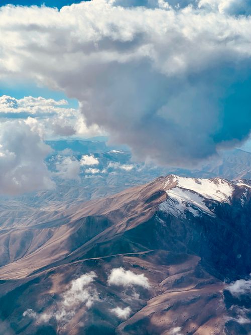 Free A scenic aerial view of snow-capped mountains under a dramatic cloudscape in Van, Turkey. Stock Photo