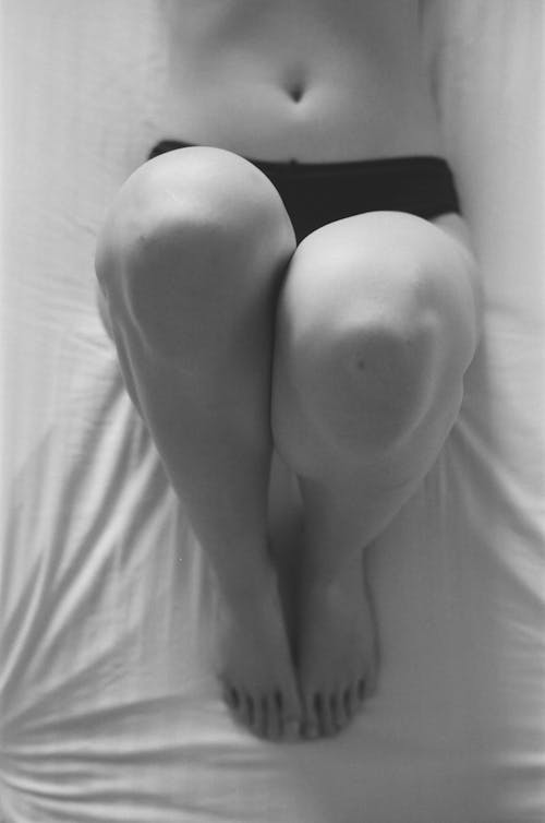 Monochrome Photo of a Woman's Knees