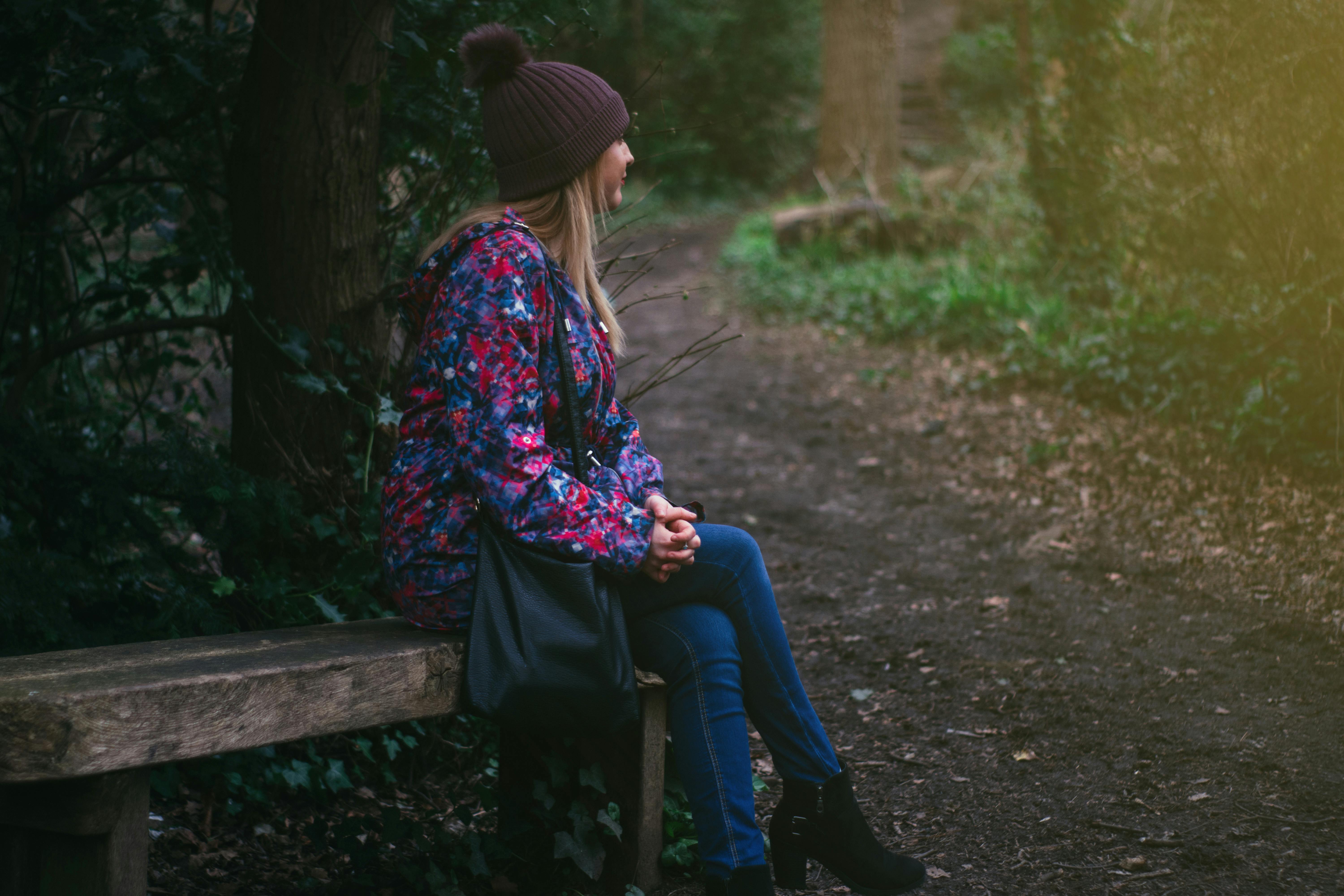 Photo of Woman Wearing Gray Dress Sitting on Bench · Free Stock Photo