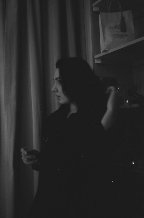 Free A woman in a black and white portrait fixing her hair indoors. Stock Photo